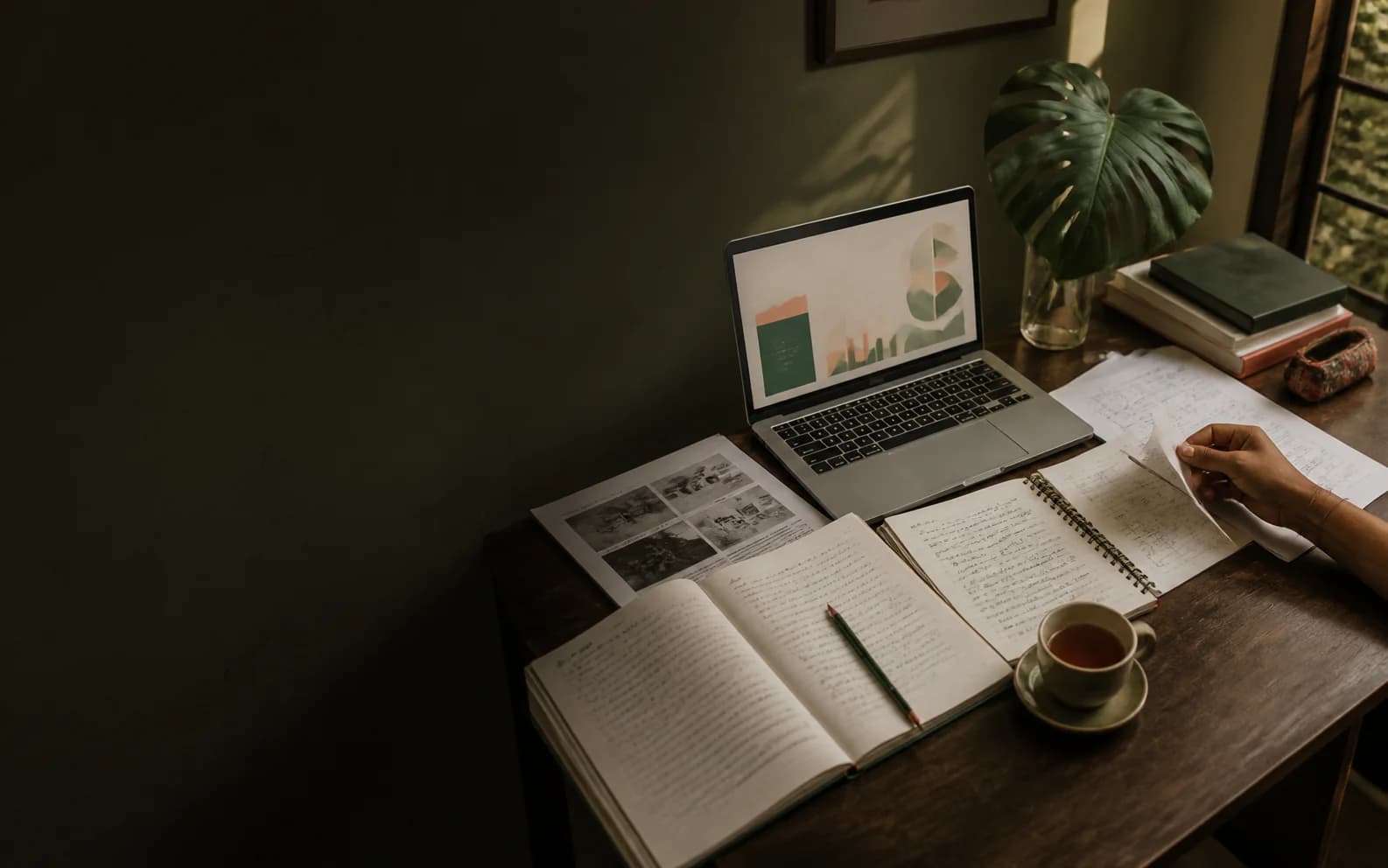 A calm study desk with research notes, a laptop and a student organising assignment work